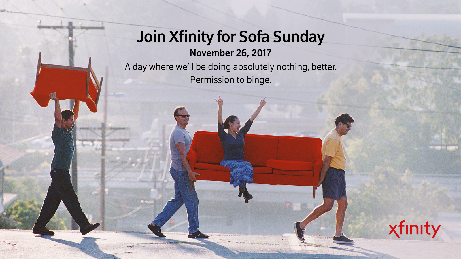 Two people carrying a couch with a third person sitting on the couch.