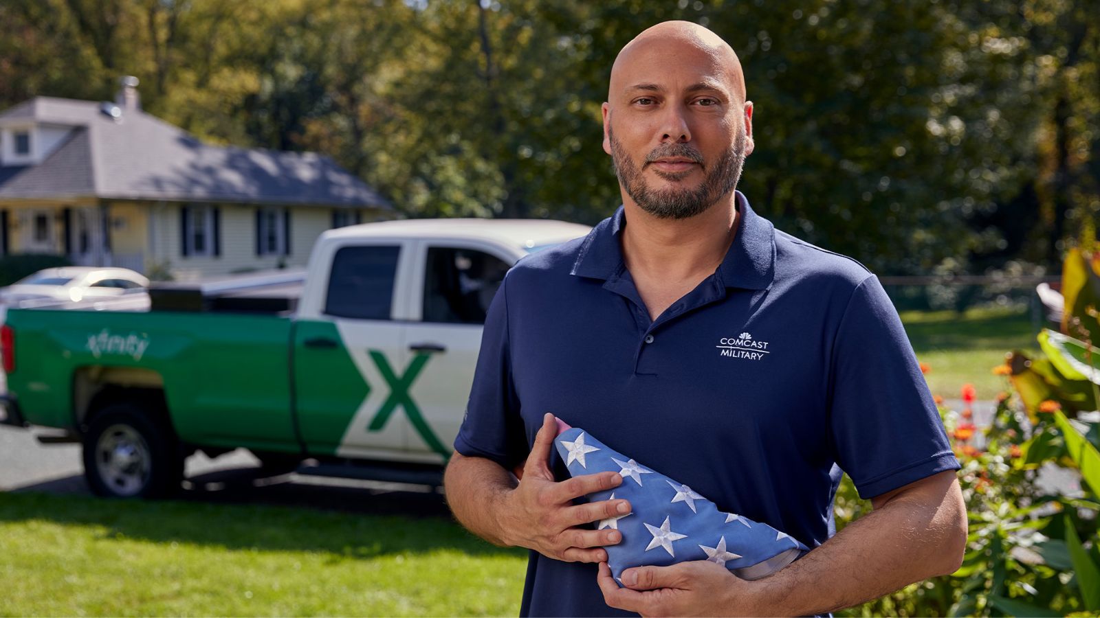 A Comcast team member preparing an American flag.
